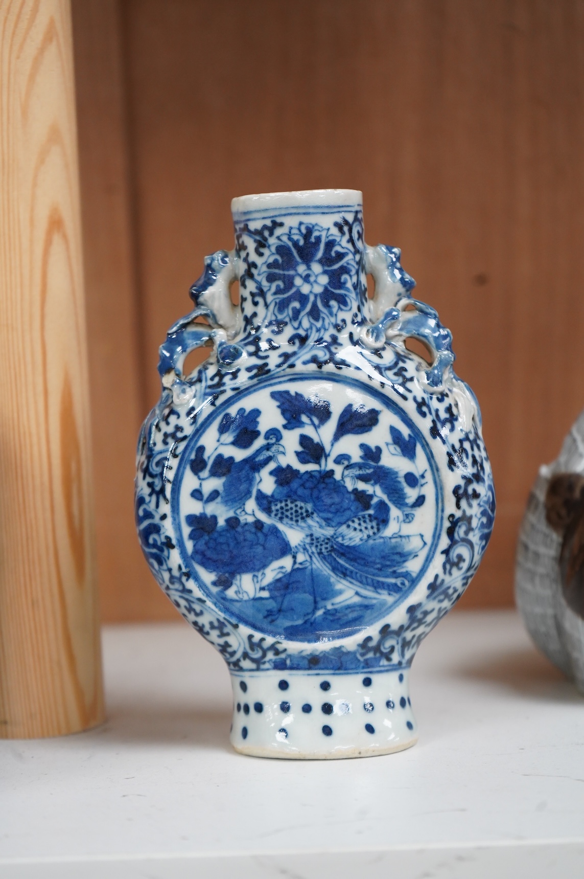 A 19th century Chinese blue and white small moon flask together with a later jar and a Portugese porcelain copy of a Chinese export cat, largest 19cm high